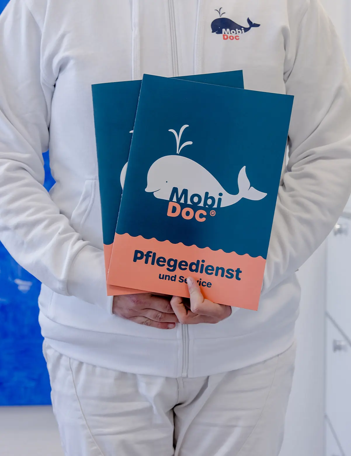 Mitarbeiter mit Mobidoc Broschüre über Pflegedienst und Service in der Hand