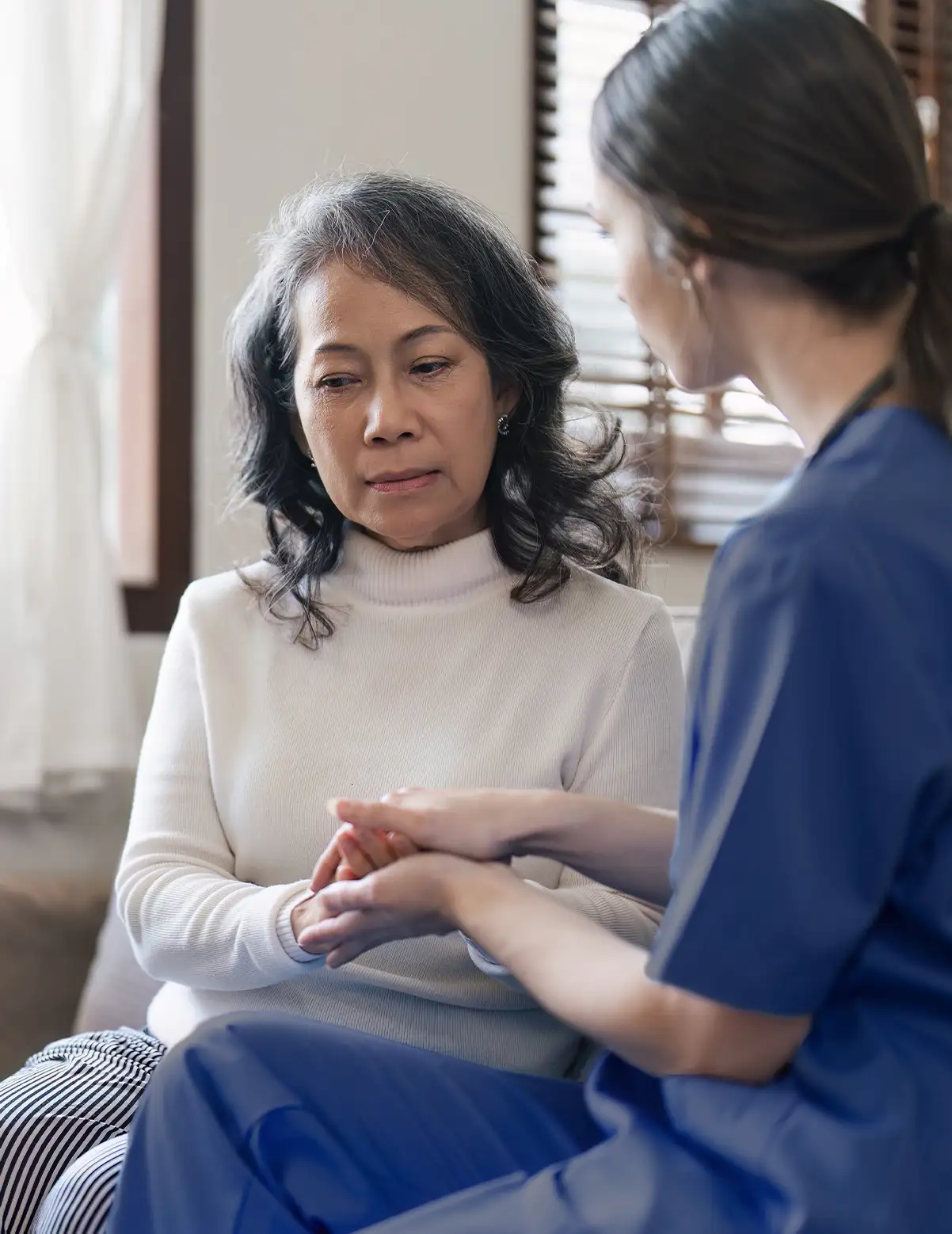 MobiDoc Pflegerin hält Hand einer Patienten