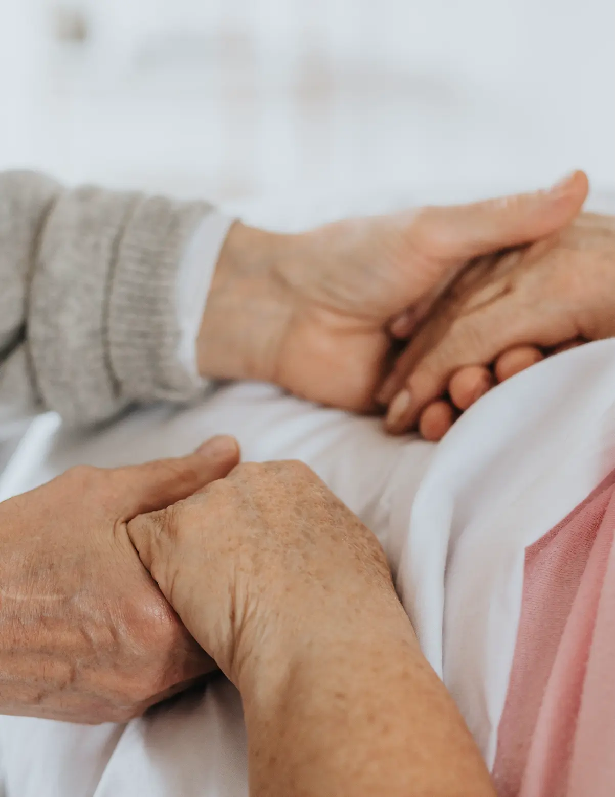 Haltende Hände am Krankenbett